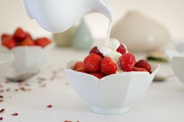 Cream Pouring From a Jug Over Fresh Strawberries clipart