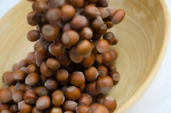 Hazelnuts in Motion Tumbling into Bamboo Bowl — Stock Photo, Image