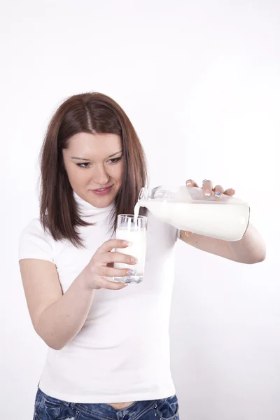 Mladá žena nalil mléko — Stock fotografie
