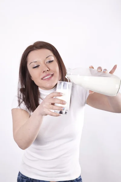 Jonge mooie vrouw gieten melk — Stockfoto