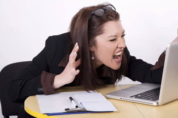 Молодая красивая женщина кричит на свой ноутбук — стоковое фото
