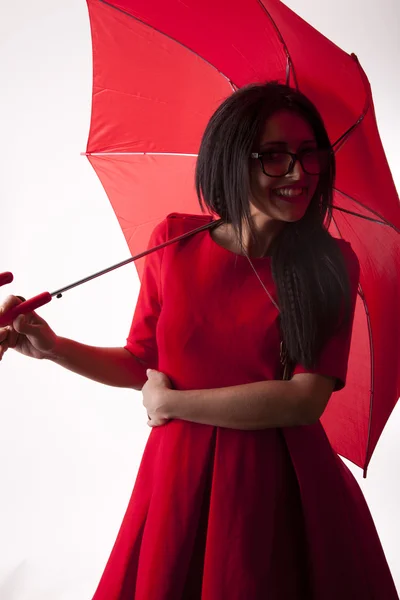 Joven atractiva mujer sexy en vestido rojo con paraguas rojo — Foto de Stock