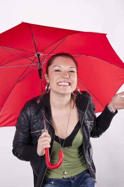 Молодая красивая девушка улыбается под красным зонтиком — стоковое фото