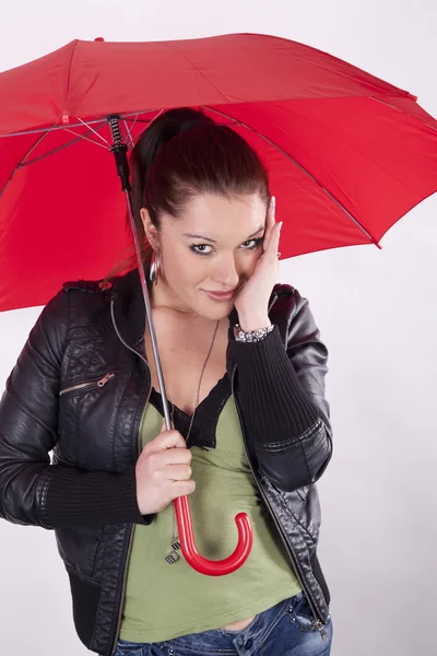 Молодая женщина под красным зонтиком — стоковое фото