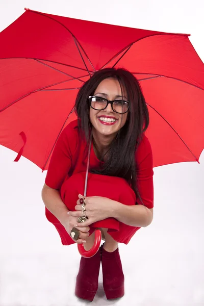 Mladá atraktivní sexy žena v červených šatech s červeným deštníkem — Stock fotografie