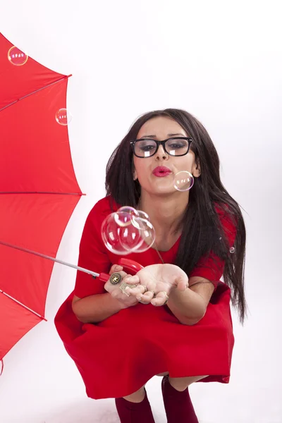 Unga attraktiva sexig kvinna i röd klänning med röda paraply — Stockfoto
