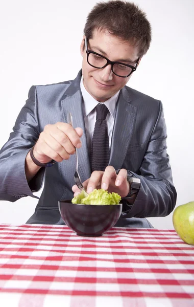 Jovem homem comendo salada — Fotografia de Stock