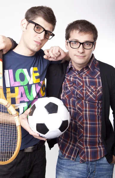Двое мужчин держат мяч и ракетку — стоковое фото