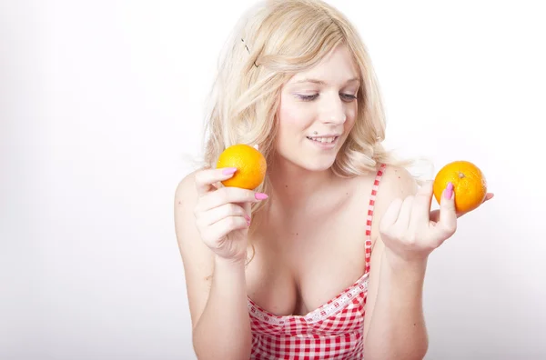 Fiatal, vonzó nő gazdaság két narancs — Stock Fotó