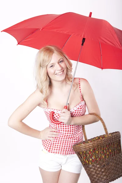Young attractive woman with red umbrella and basket — Stock Photo, Image