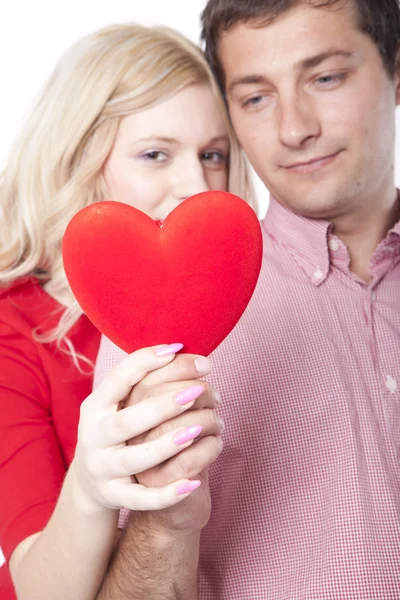 Jovem casal feliz segurando um coração — Fotografia de Stock