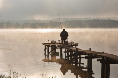 Fisherman to lake at first light clipart
