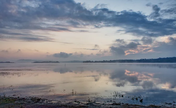 Dramático amanecer sobre un lago tranquilo — Foto de Stock