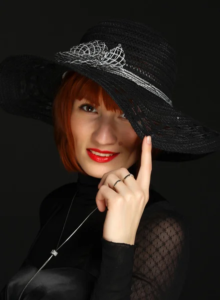 Femme aux lèvres ouvertes en chapeau noir sur fond sombre — Photo