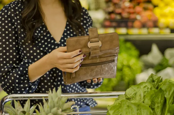年轻女子在超级市场打开钱包 — 图库照片