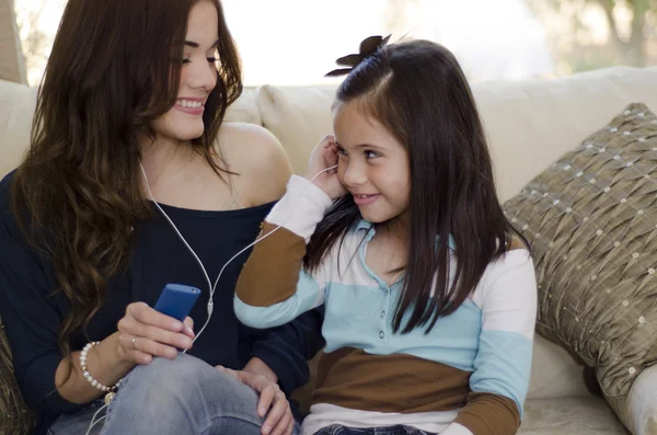 Joven hermosa madre escuchando música con su hija —  Fotos de Stock