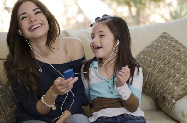 Jonge mooie moeder luisteren naar muziek met haar dochter — Stockfoto