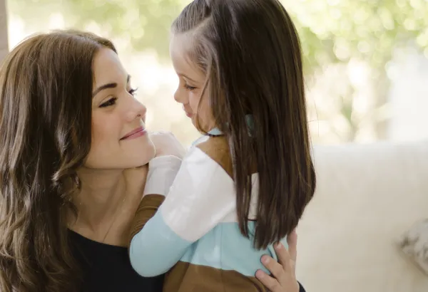 Young beautiful mother and daughter looking at each other and smiling — Stock Photo, Image