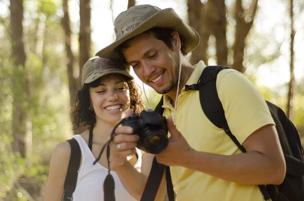 Roztomilý mladý pár při pohledu na fotografie z jejich pěší výlet — Stock fotografie