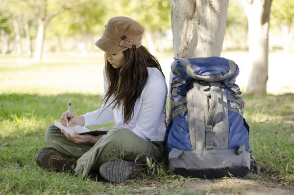 Junge schöne Frau schreibt in einem Tagebuch über ihre Wanderreise — Stockfoto