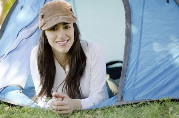 Joven hermosa mujer sonriendo fuera de una tienda de campaña en un viaje de camping —  Fotos de Stock