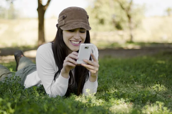 Junge schöne Frau sendet während einer Wandertour einen Text auf ihr Handy — Stockfoto