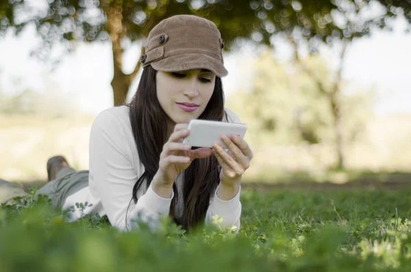 Όμορφη κοπέλα που στέλνει ένα κείμενο στο κινητό της ανάπαυσης για πεζοπορία ταξίδι, ενώ — Φωτογραφία Αρχείου