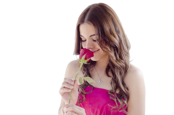 Cute young girl smelling a red rose — Stock Photo, Image