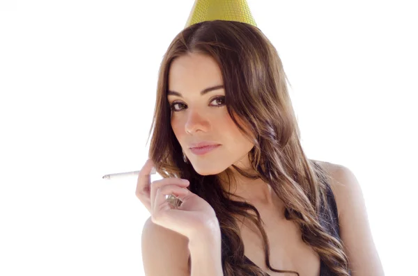 Young beautiful woman with a party hat lighting a cigarette — Stock Photo, Image