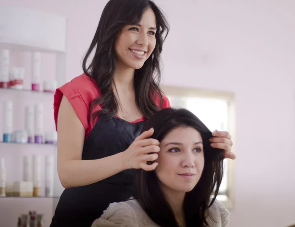 Unga kvinnliga frisör visar slutresultatet till kund — Stockfoto