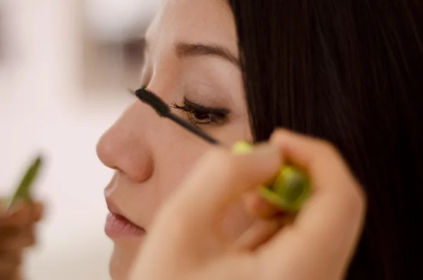 Nahaufnahme eines Maskenbildners, der einem Kunden Wimperntusche aufsetzt — Stockfoto