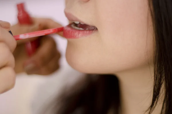 Gros plan d'un maquilleur mettant du rouge à lèvres sur un client — Photo