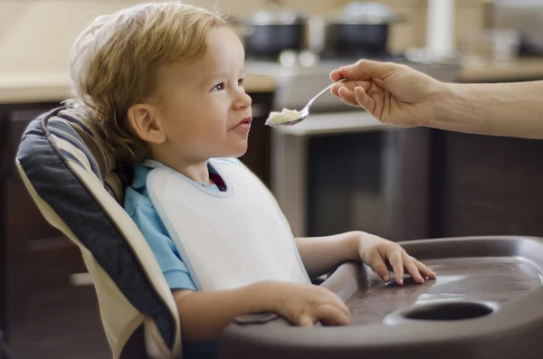Cute boy being fed by his mom — Stock Photo, Image