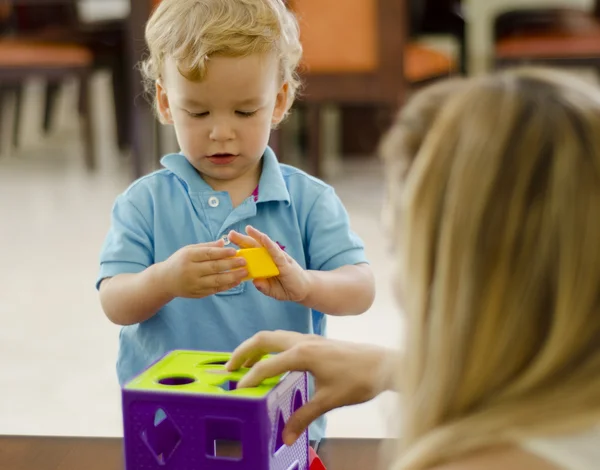 Cute boy and mother playing with a puzzle — Stock Photo, Image