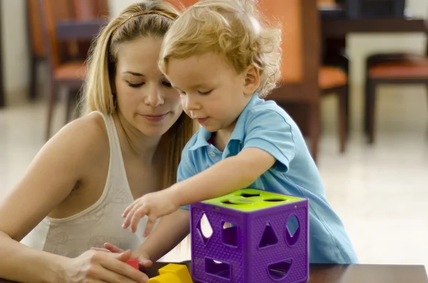 Милый мальчик и мама играют с головоломкой — стоковое фото