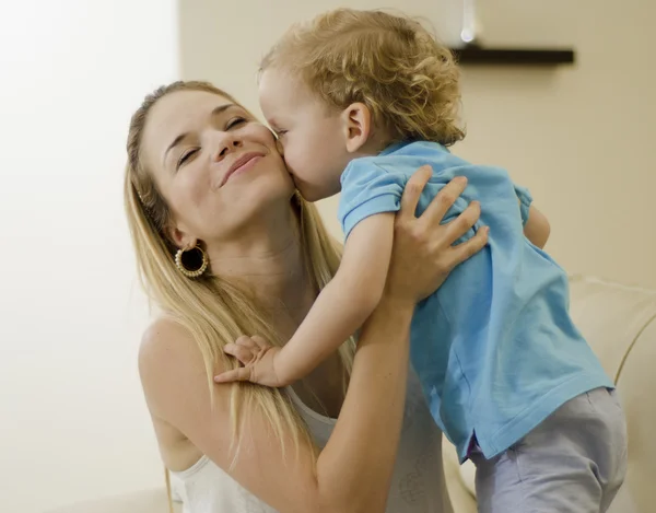 Lindo chico besando a su mamá en la mejilla — Foto de Stock