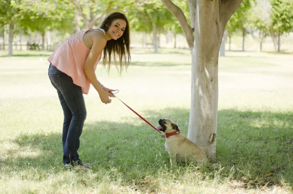 Sevimli genç bir kadın köpeğini bir parkta yürüyüş — Stok fotoğraf