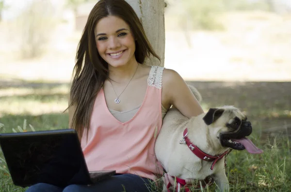 Söt ung kvinna tillbringar tid med sin hund i parken — Stockfoto