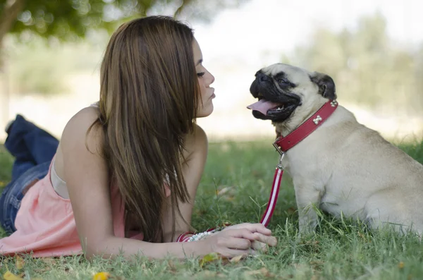 Parkta öpücük onun köpeği için üfleme genç güzel kadın — Stok fotoğraf