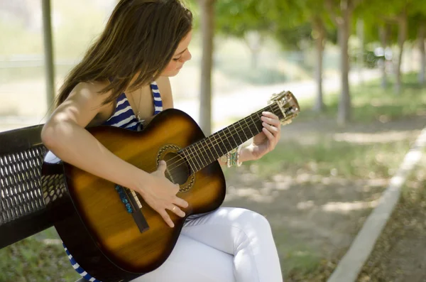 Милая молодая женщина играет музыку в парке — стоковое фото