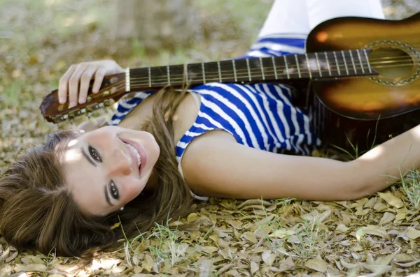 Cute young woman relaxing at the park with her guitar — Stock Photo, Image