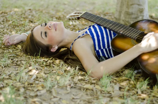 Linda joven mujer relajándose en el parque con su guitarra —  Fotos de Stock