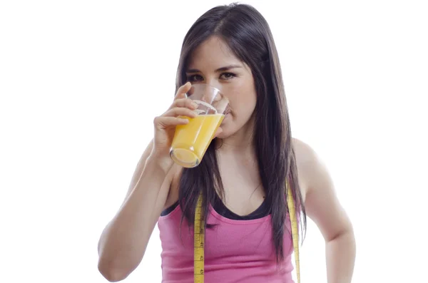 Молода красива жінка в спортивному вбранні п'є апельсиновий сік — стокове фото