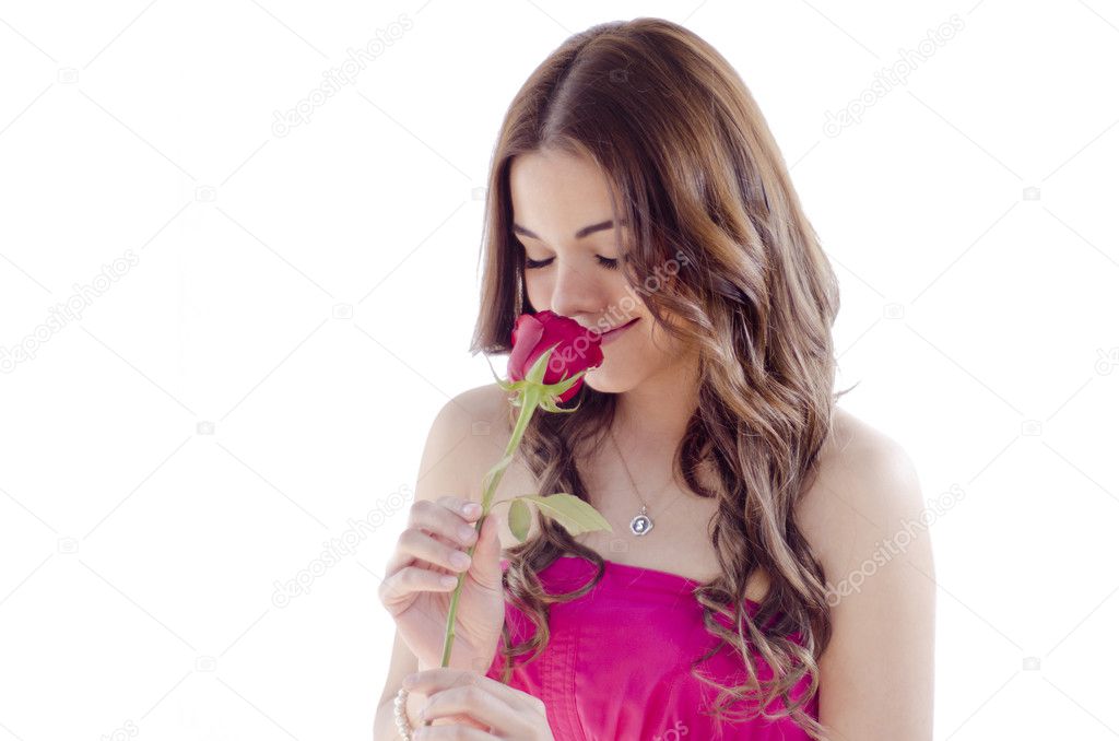 Cute young girl smelling a red rose