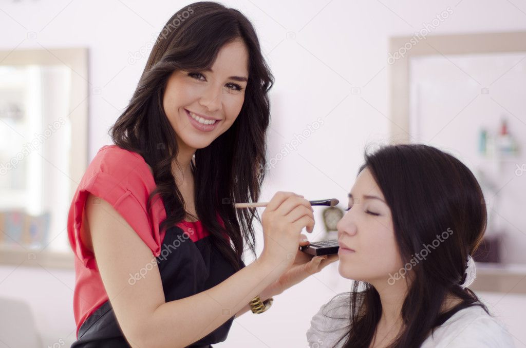 Female makeup artist applying makeup on a client