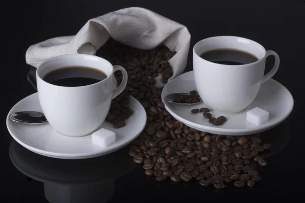 Duas xícaras de café e açúcar no espelho preto — Fotografia de Stock