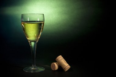 Art for beverages. White wine in a glass, on black-green backgro clipart