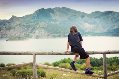 Child looking at a landscape clipart