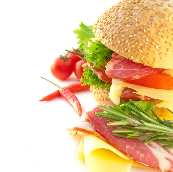 Sandwich from a roll, meat, cheese and a tomato — Stock Photo, Image