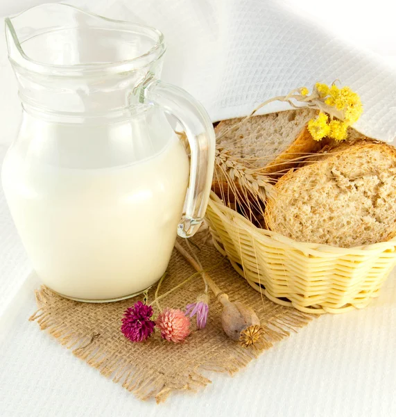 Jarra con leche, pan y flores silvestres — Foto de Stock